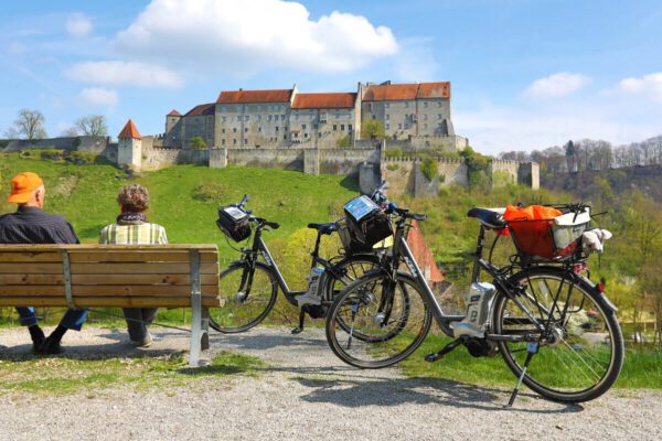Seniorenpaar bei einem Fahrradausflug mit Burgpanorama © Burghauser Touristik GmbH