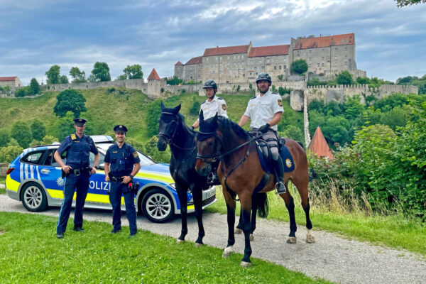 Zwei berittene Polizisten und zwei Polizisten mit Streifenwagen mit Bugpanorama © Stadt Burghausen