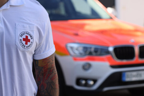 Sanitäter des Deutschen Roten Kreuzes mit Notarztwagen im Hintergrund © Gerhard Nixdorf Sanitäter des Deutschen Roten Kreuzes mit Notarztwagen im Hintergrund © Gerhard Nixdorf