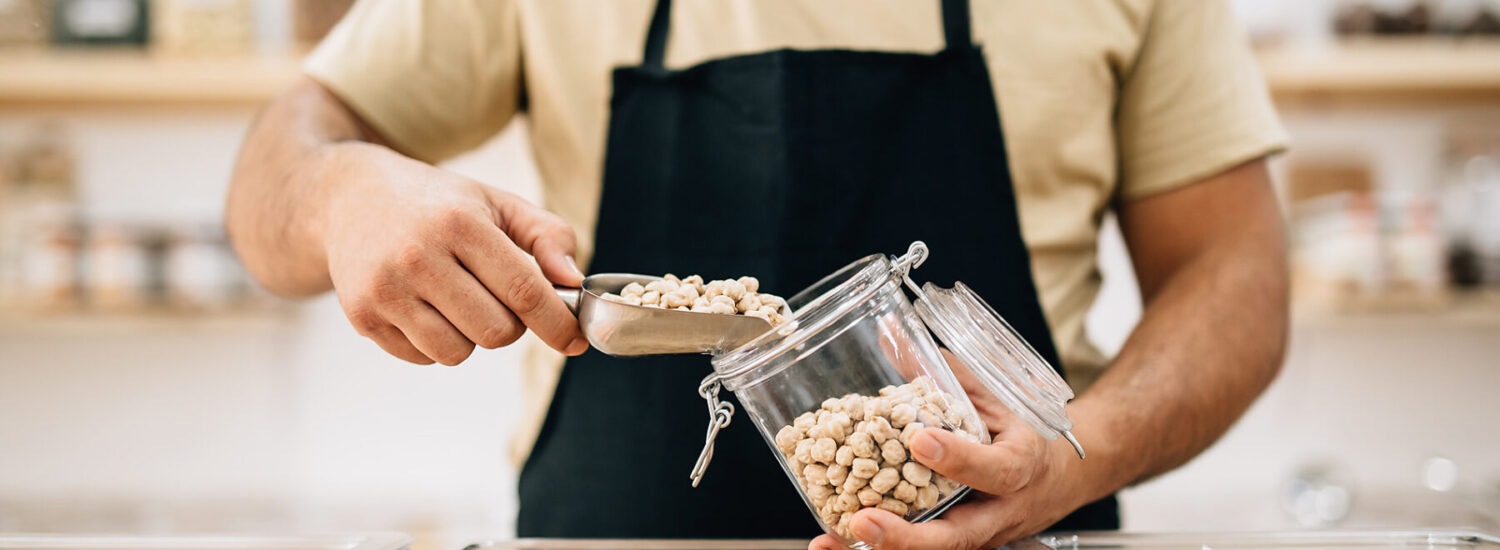 Verkäufer füllt Kichererbsen in ein Glas © Westend61 / Addictive Stock / Alex Salcedo Verkäufer füllt Kichererbsen in ein Glas © Westend61 / Addictive Stock / Alex Salcedo
