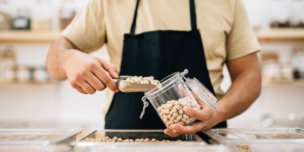 Verkäufer füllt Kichererbsen in ein Glas © Westend61 / Addictive Stock / Alex Salcedo