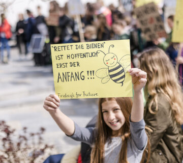 Ein Mädchen hält eine Schild auf einer Demo hoch © Westend61 / Stefanie Baum