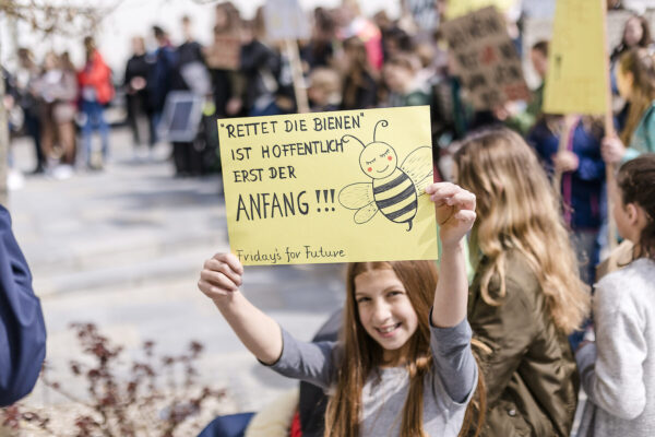 Ein Mädchen hält eine Schild auf einer Demo hoch © Westend61 / Stefanie Baum