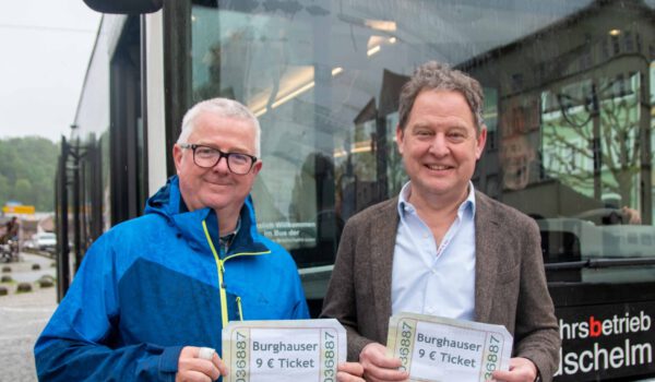 Erster Bürgermeister Florian Schneider (l.) und Martin Hinterwinkler, Leiter des Ordnungsamts in Burghausen, mit symbolischen 9-Euro-Tickets am Stadtplatz. Fotocredit: Stadt Burghausen/ebh
