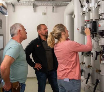 Climate protection manager Verena Steiner with Michael Madl (middle) from building management and Thomas Lanner (left), caretaker of the Franz Xaver Gruber School, checking the boiler room © Stadt Burghausen/ebh