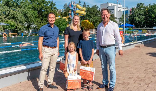 Familie Reichardt waren die 100.000sten Badegäste in der Freibad-Saison 2023. Erster Bürgermeister Florian Schneider (r.) und kaufmännischer Bäderleiter Stefan Sajdak (l.) überraschten die Familie mit einer kleinen Ehrung © Stadt Burghausen / ebh