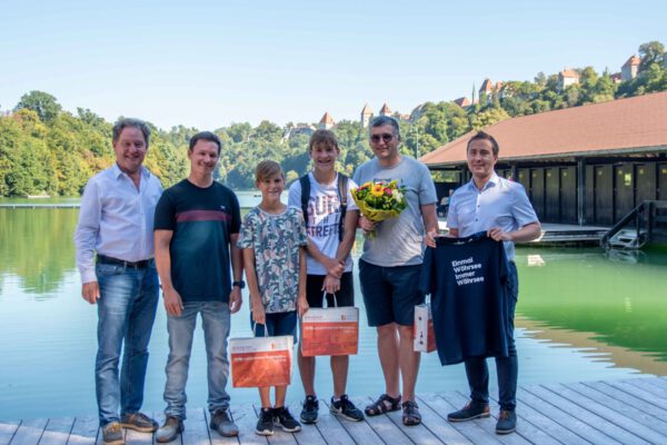 Familie Waas bekam ein Geschenk, denn Sohn Jakob war der 100.000ste Badegast. Im Geschenk waren z.B. Flip Flops, Schwimmbrillen und ein Wöhrsee-Tshirt sowie eine Saisonkarte für 2024. V.l.n.r.: Erster Bürgermeister Florian Schneider, Wöhrseebad-Betriebsleiter Dennis Clemens, Jakob und Felix Waas, Bernhard Waas und kaufmännischer Bäderleiter der Bäder Burghausen Stefan Sajdak © Stadt Burghausen/ebh Familie Waas bekam ein Geschenk, denn Sohn Jakob war der 100.000ste Badegast. Im Geschenk waren z.B. Flip Flops, Schwimmbrillen und ein Wöhrsee-Tshirt sowie eine Saisonkarte für 2024. V.l.n.r.: Erster Bürgermeister Florian Schneider, Wöhrseebad-Betriebsleiter Dennis Clemens, Jakob und Felix Waas, Bernhard Waas und kaufmännischer Bäderleiter der Bäder Burghausen Stefan Sajdak © Stadt Burghausen/ebh
