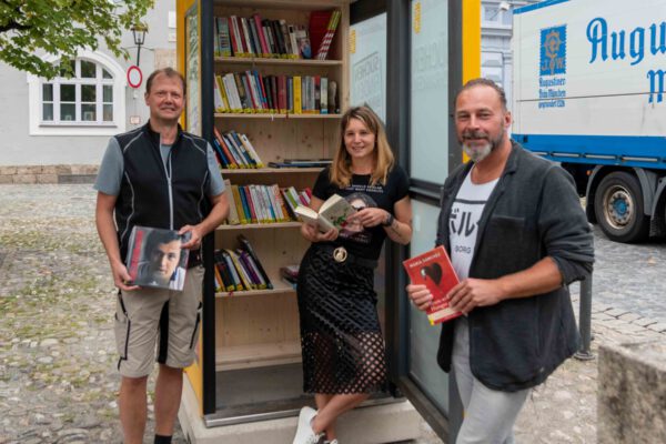 Markus Salzinger, städtischer Schreiner, Christin Moll, Leiterin der Stadtbibliothek, und Peter Schweikl, Leiter der Bauhofs, mit der Bücherzelle am Stadtplatz. © Stadt Burghausen/ebh