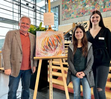 Photo - “Live work” at the seniors' afternoon: Burghausen artist Katalin Harrer conjured up an expressive motif on the canvas that will be auctioned off to the highest bidder for a good cause. Senior speaker Heiz Donner, Katrin Scheitz (from left) and Elena Wagenhofer are looking forward to hopefully many bids. Photo credit: City of Burghausen /köx