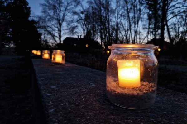 Viele Kerzen flackerten zur Gedenkveranstaltung für die Opfer des Holocaust am 27. Januar 2024 auf den Mauern im Botanischen Garten. Die Mauern stellen den Grundriss der Villa Galitzenstein dar. Fotocredit: Stadt Burghausen/ebh