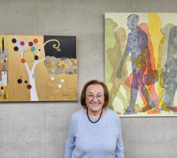 Katalin Harrer vor zwei ihrer Werke, die im Haus der Familie ausgestellt sind. © Haus der Familie