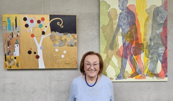 Katalin Harrer vor zwei ihrer Werke, die im Haus der Familie ausgestellt sind. © Haus der Familie