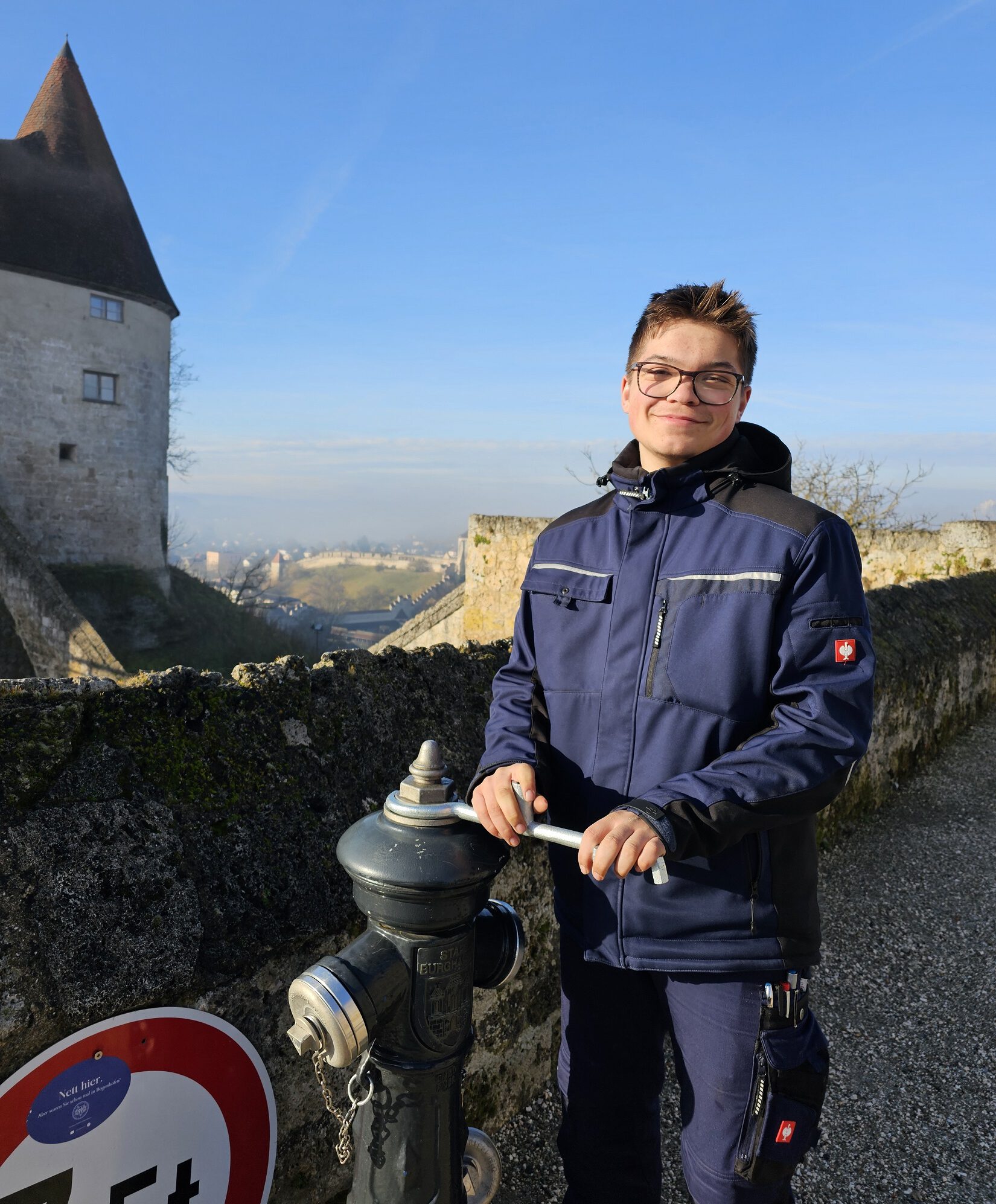 Luca Ringsquandl, Auszubildender zur Fachkraft für Wasserversorgungstechnik bei den Stadtwerken Burghausen, kontrolliert einen der Hydranten auf der Burg © Stadt Burghausen/ebh