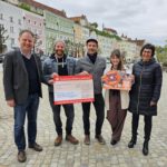 The organizers of the charity street music festival happily accepted the donation amount, which had been increased to €10.000 by the city. From left: First Mayor Florian Schneider, the organizers Max Roxton, Erik Bönisch, Susanne Kramlinger and Sigrid Resch, managing director of Burghauser Touristik GmbH. Photo credit: City of Burghausen