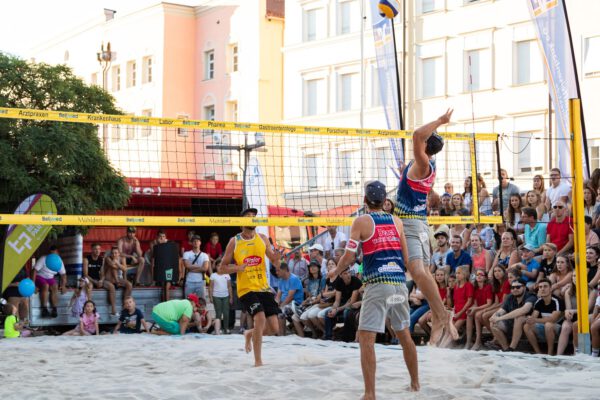 Im Juli 2024 wird am Stadtplatz hochkarätiges Volleyball gespielt. Zuschauer dürfen auf Tribünen Platz nehmen und sind herzlich willkommen. Die Burghauser Gastronomie freut sich auf die Gäste. Fotocredit: Fabian Bartsch (Volleyball)