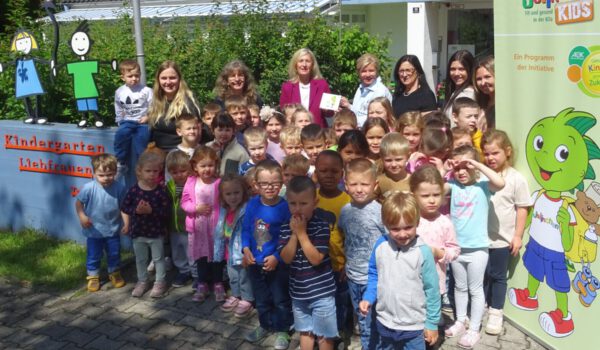 Die Kita Liebfrauen Burghausen ist Jolin-chenKids-Einrichtung. Angela Adelsperger-Birk von der AOK (Mitte.) überreichte das Türschild an Einrichtungsleiterin Esther Wallinger (4.v.re.) und an die Leiterinnen der einzelnen Gruppen mit den Burghausener Kindern