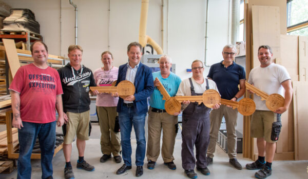 Stolze Schlüssel-Hersteller in der Schreinerei der Rupert Werkstätten Altötting: Armin Birndorfner (v.l.), Gruppenleiter Bichlmeier Christian, Kleiner Elisabeth, Erster Bürgermeister von Burghausen Schneider Florian, Freimüller Renate, Lohr Maximilian, Einrichtungsleiter Zumüller Günther sowie Gruppenleiter Meindl Andreas. Fotocredit: Stadt Burghausen/köx