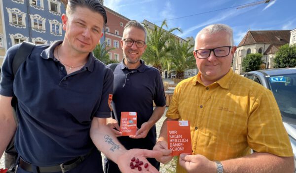 „Ein Herz für Richtigparker“ steht auf den Gummibärchen. „Wir sagen herzlich Dankeschön“ auf der orangen Postkarte. Umseitig erklärt die Stadt Burghausen, was alles richtiggemacht wurde: u.a. keine Geh- oder Radwege blockiert, mit gültiger Parkschreibe geparkt, keine Rettungswege blockiert etc. Verkehrsüberwacher Stefan Wormeck (v.l.), Jens Fichtner und Ordnungsamtsleiter Martin Hinterwinkler zeigen die herzliche Botschaft. Fotocredit: Stadt Burghausen/Königseder