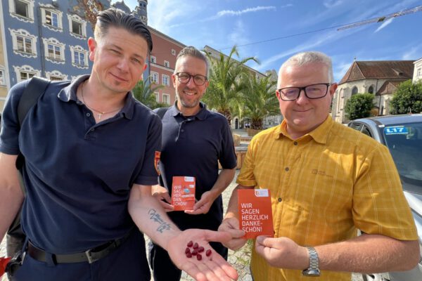 „Ein Herz für Richtigparker“ steht auf den Gummibärchen. „Wir sagen herzlich Dankeschön“ auf der orangen Postkarte. Umseitig erklärt die Stadt Burghausen, was alles richtiggemacht wurde: u.a. keine Geh- oder Radwege blockiert, mit gültiger Parkschreibe geparkt, keine Rettungswege blockiert etc. Verkehrsüberwacher Stefan Wormeck (v.l.), Jens Fichtner und Ordnungsamtsleiter Martin Hinterwinkler zeigen die herzliche Botschaft. Fotocredit: Stadt Burghausen/Königseder