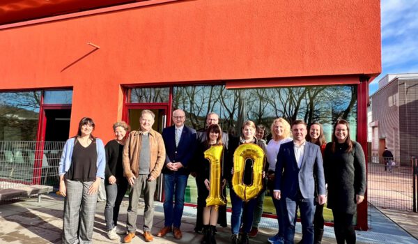 Foto im neuen Außenbereich der Kita Kunterbunt mit altem und neuen Träger (v.l.): Haben eine 10 mitgebracht, weil die Burghauser Kita Kunterbunt die 10. Kita in der Trägerschaft des BRK Kreisverbands ist. Mariella Röben, Leitung der Geschäftsstelle, Sabina Schneider-Reisinger, Vorstand Kinderschutzbund Burghausen-Altötting, Erster Bürgermeister Florian Schneider, Herbert Hofauer, Vorsitzender des BRK-Kreuzverbandes Altötting, Sabine Meier und Martina Klinger vom BRK, Verena Novak und Conny Reichert von der Kita Kunterbunt, Max Gschwendtner Leitung BRK Kinder- Jugendbereich, Christine Auberger, Leitung Haus der Familie und Daniela Spiegelhauer von der städtischen Kämmerei zuständig für die Burghauser Kitas. Fotocredit: Stadt Burghausen / Königseder