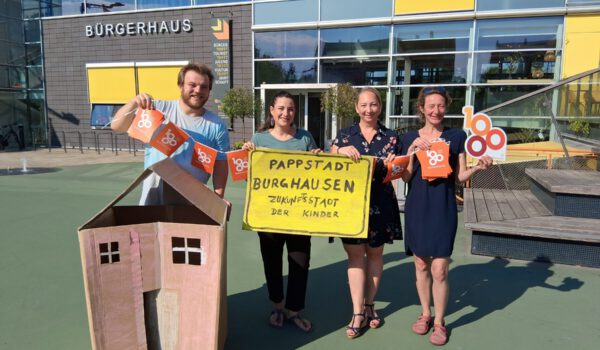 Ein Gebäude gibt es schon, sie hoffen auf viele weitere: Die Initiatoren der Bastelaktion „Pappstad“ (v.l.) Marcel Anslinger (Leiter Freizeitheim), Mariella Röben (Kinderschutzbund), Simone Mayer (Werbering) und Monika Lengyel (Freizeitheim).