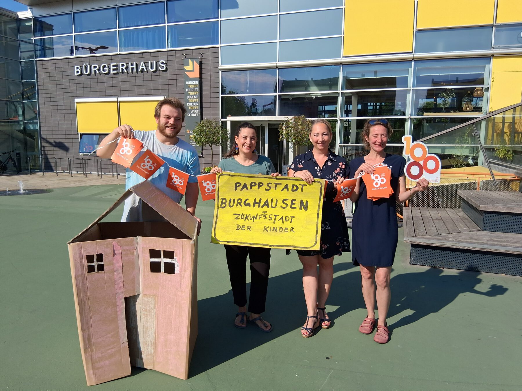 Ein Gebäude gibt es schon, sie hoffen auf viele weitere: Die Initiatoren der Bastelaktion „Pappstad“ (v.l.) Marcel Anslinger (Leiter Freizeitheim), Mariella Röben (Kinderschutzbund), Simone Mayer (Werbering) und Monika Lengyel (Freizeitheim).