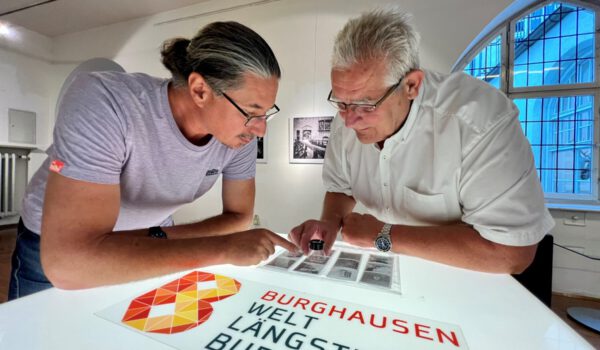 Zweiter Bürgermeister Norbert Stranzinger in der Ausstellung mit dem Fotografen Daniel Mittermeier aus München. Er Negative mitgebracht, die mit einer Lupe anzuschauen sind. Fotocredit: Stadt Burghausen / Königseder