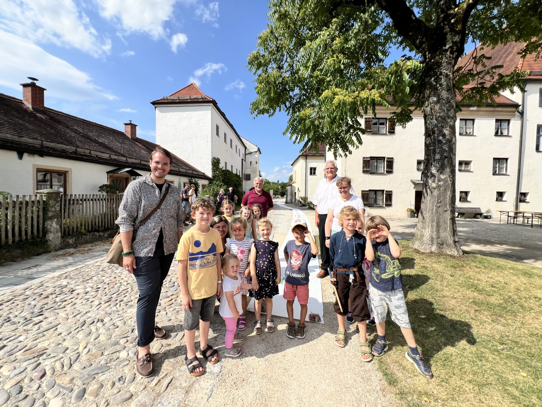 Stellv. Einrichtungsleiter Maximilian Weiß (v.l.), Einrichtungsleiterin St. Konrad Kita Claudia Pronold, Burgverwalter Heinz Donner, Zweiter Bürgermeister Norbert Stranzinger und Museumsreferentin Dr. Tanja Kohwagner mit Burghauser Kindern, die mitgemalt haben. Tanja Kohwagner hat die Führungen in der Hedwigskapelle gemacht. Fotocredit: Stadt Burghausen / Königseder