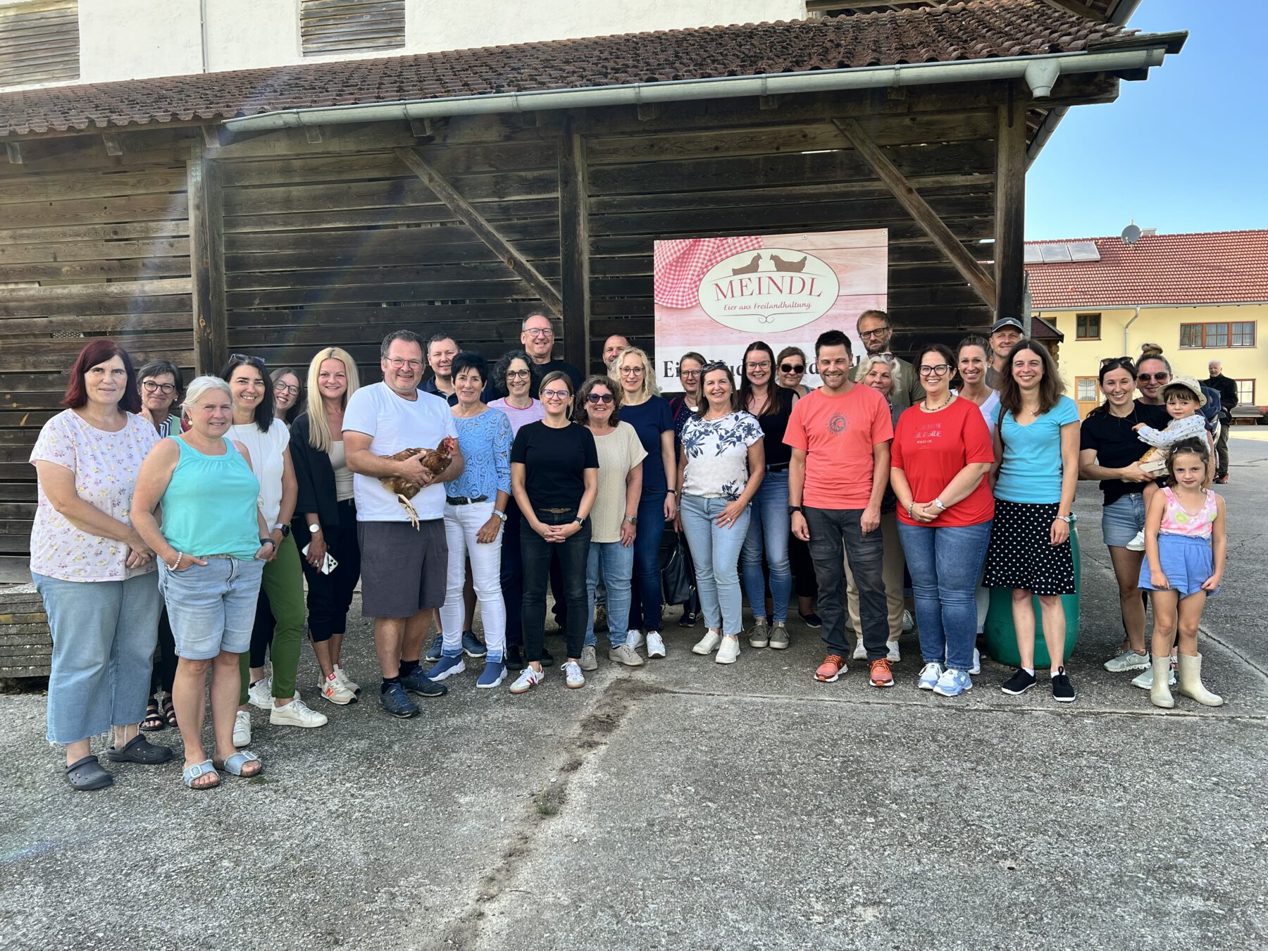 Gruppenbild: Ein Teil der Besuchstruppe von der Stadtverwaltung Burghausen vor dem Hühnerstall in Silmoning mit Blick auf Marienberg. Die Kolleginnen und Kollegen der Stadt Burghausen haben sich herzlich bei Georg Meindl und seiner Familie für die großzügige Einladung mit Speis und Trank sowie der lehrreichen Führungen bedankt. Fotocredit: Stadt Burghausen / köx