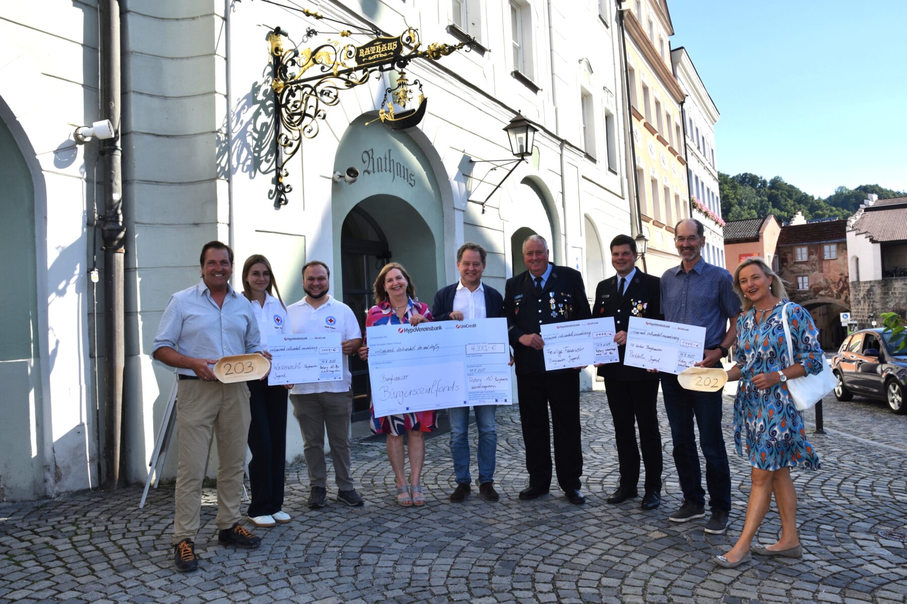 Spendenübergabe für den guten Zweck: (v.l.) Heiner Hintermeier, Rotary Club Altötting-Mühldorf, Jugendleiterin Katrin Huber und Vorsitzender Robert Mayer (beide Wasserwacht Burghausen), Sozialamtleiterin Elisabeth Rummert, Erster Bürgermeister Florian Schneider, Jugendwart Anton Maier und Markus Szehr (beide Freiwillige Feuerwehr Burghausen), Stefan Obereder (Paddler SV Wacker) sowie Annette Hopf, ehemalige Präsidentin Rotary Club Altötting-Burghausen.