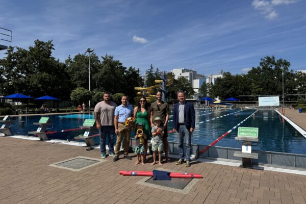 Erster Bürgermeister Florian Schneider (v.r.) begrüßte die Burghauser Familie Rene Kreil sowie Julia Resch mit den Kindern Luca und Jonas. Bäderleiter Stefan Sajdak und Florian Moser überreichten dem 100.000 Badegast einen Gutschein sowie Ringe zum Auftauchen, eine Poolnudel und für die Mama einen Blumenstrauß. © Bäder Burghausen Erster Bürgermeister Florian Schneider (v.r.) begrüßte die Burghauser Familie Rene Kreil sowie Julia Resch mit den Kindern Luca und Jonas. Bäderleiter Stefan Sajdak und Florian Moser überreichten dem 100.000 Badegast einen Gutschein sowie Ringe zum Auftauchen, eine Poolnudel und für die Mama einen Blumenstrauß. © Bäder Burghausen