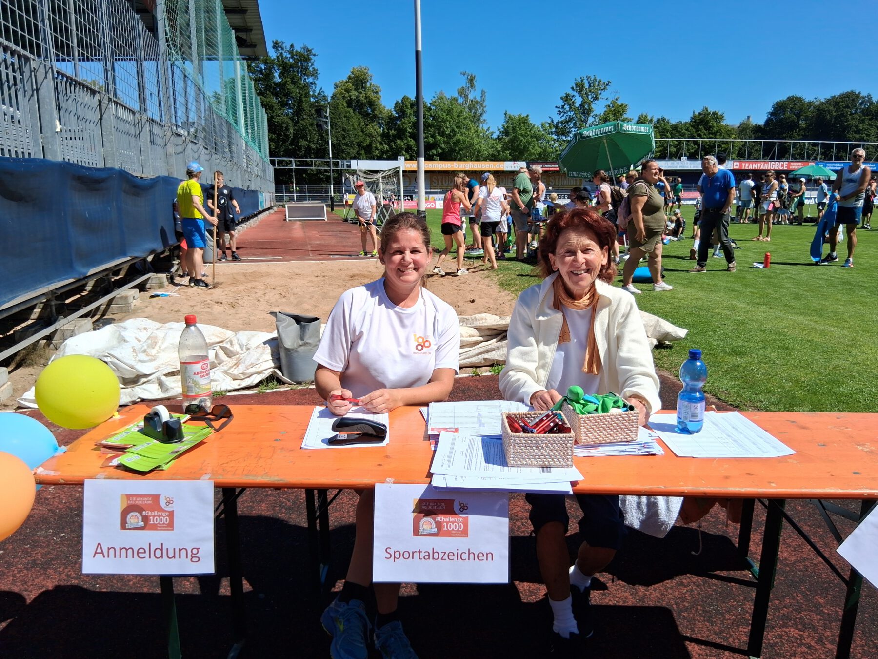 Beim Sportabzeichentag im Rahmen des SV Wacker-Sommerfests am 19. Juli saß BLSV-Sportabzeichenreferentin Ulrike Stowasser (l.) selbst bei der Anmeldung – die Teilnehmerzahlen an diesem Tag waren ein Rekord. Nun hoffen alle Beteiligten auf das Erreichen des 1000er-Ziels. Fotocredit: Stadt Burghausen/tg