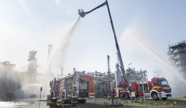 Zwei Feuerwehrfahrzeuge führen eine Löschübung in einer chemischen Produktionsanlage durch.