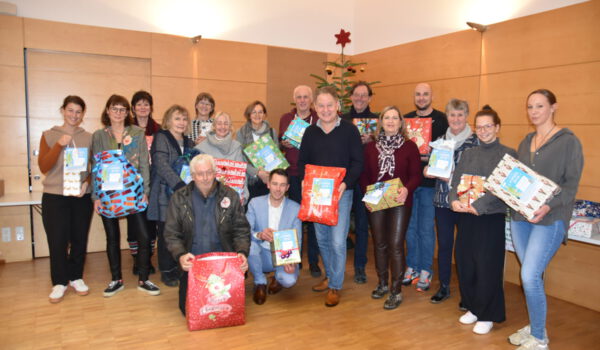 Erster Bürgermeister Florian Schneider übergibt die liebevoll verpackten Geschenke an die elf Einrichtungen, die die Wünsche ans Bürgerhaus-Team übermittelt haben. Fotocredit: Stadt Burghausen / köx