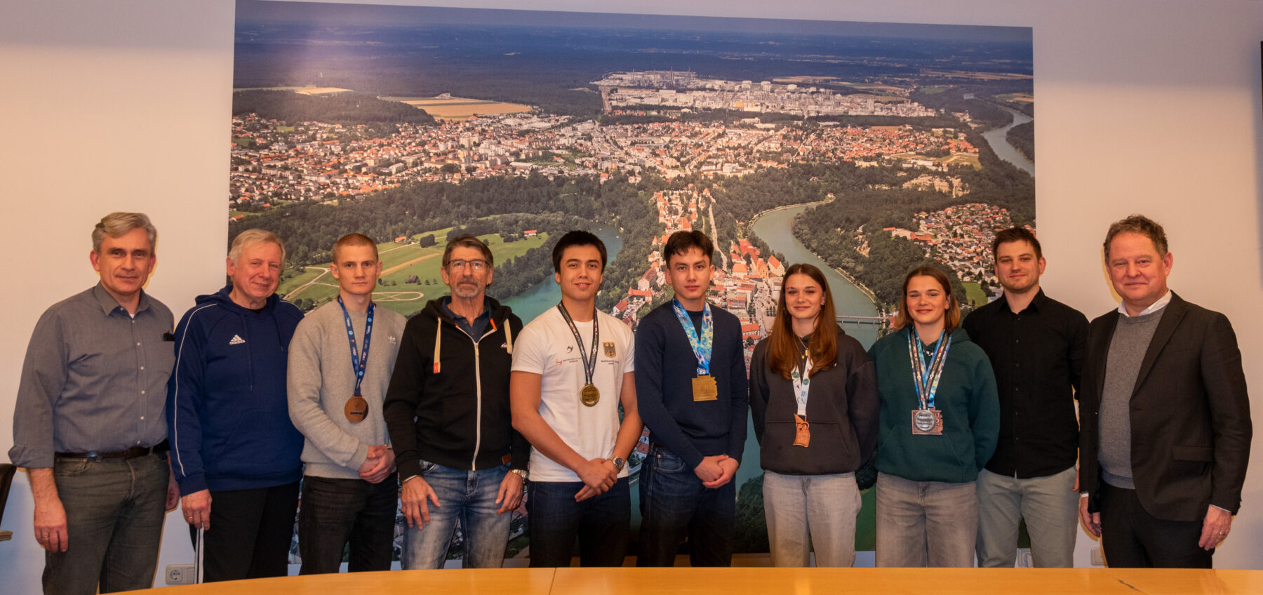Foto: v.l. Nicolas Jost, Gerhard Walter, Eugen Ill, Robert Rogger, Vincent Jost, Jonathan Jost, Stella Hartel, Clara Hartel, Werner Giermaier, Erster Bürgermeister Florian Schneider. Fotocredit: Stadt Burghausen / Königseder