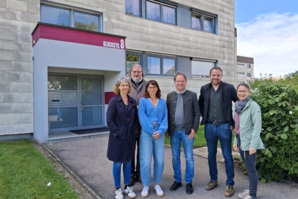 : Die Bewohner der Gluckstraße 2-9 können künftig mit sicherer und nachhaltiger Energie durch Fernwärme heizen. Zum Vor-Ort-Termin kamen (v.l.) Tanja Erb, Geschäftsführerin EBG, Umweltreferent und Beirat Gunter Strebel, Mit-Eigentümerin und Beirätin Christin Moll, Erster Bürgermeister Florian Schneider, Stefan Huber (EBG) und Hausverwalterin Katrin Bader-Schwaninger.