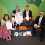 Foto: Vier Stempel einsammeln und – Bingo! So funktioniert der Sommerlesespaß in der Stadtbibliothek  Das Team der Stadtbibliothek mit Leiterin Christin Moll und Mitarbeiterin Monika Vornehm ist bereit für den Kinderansturm, Sebastian Rauschecker und David Gergely Komaromi von der Sparkasse Burghausen sponserten dieses Mal die Sofortgewinne  Fotocredit: Stadt Burghausen/tg