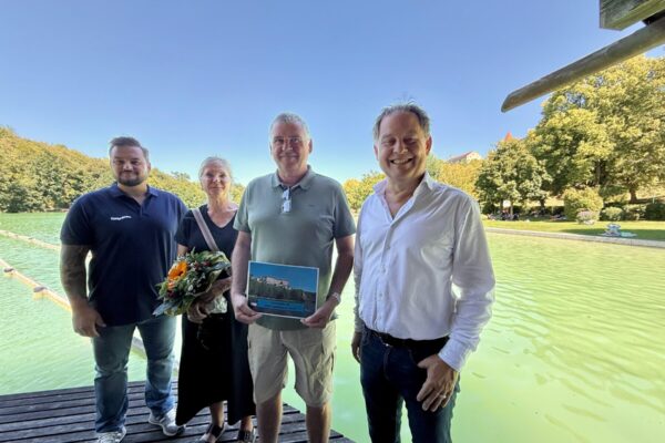 Erster Bürgermeister Florian Schneider und Bäderleiter Florian Moser begrüßten das Ehepaar Rosmarie und Richard Siegerd aus Haiming als 100.000 Badegäste. Das Ehepaar ist Stammgast und besucht den See mindestens vier Mal pro Woche. „Wir schätzen die sehr gute Wasserqualität und die natürliche Beschattung. Das Flair ist einzigartig und wenn wir am Vormittag da sind ist es auch noch schön ruhig“, so die Siegerds. Als kleine Aufmerksamkeit überreicht das Stadtoberhaupt Blumen und eine Saisonkarte für das nächste Jahr.